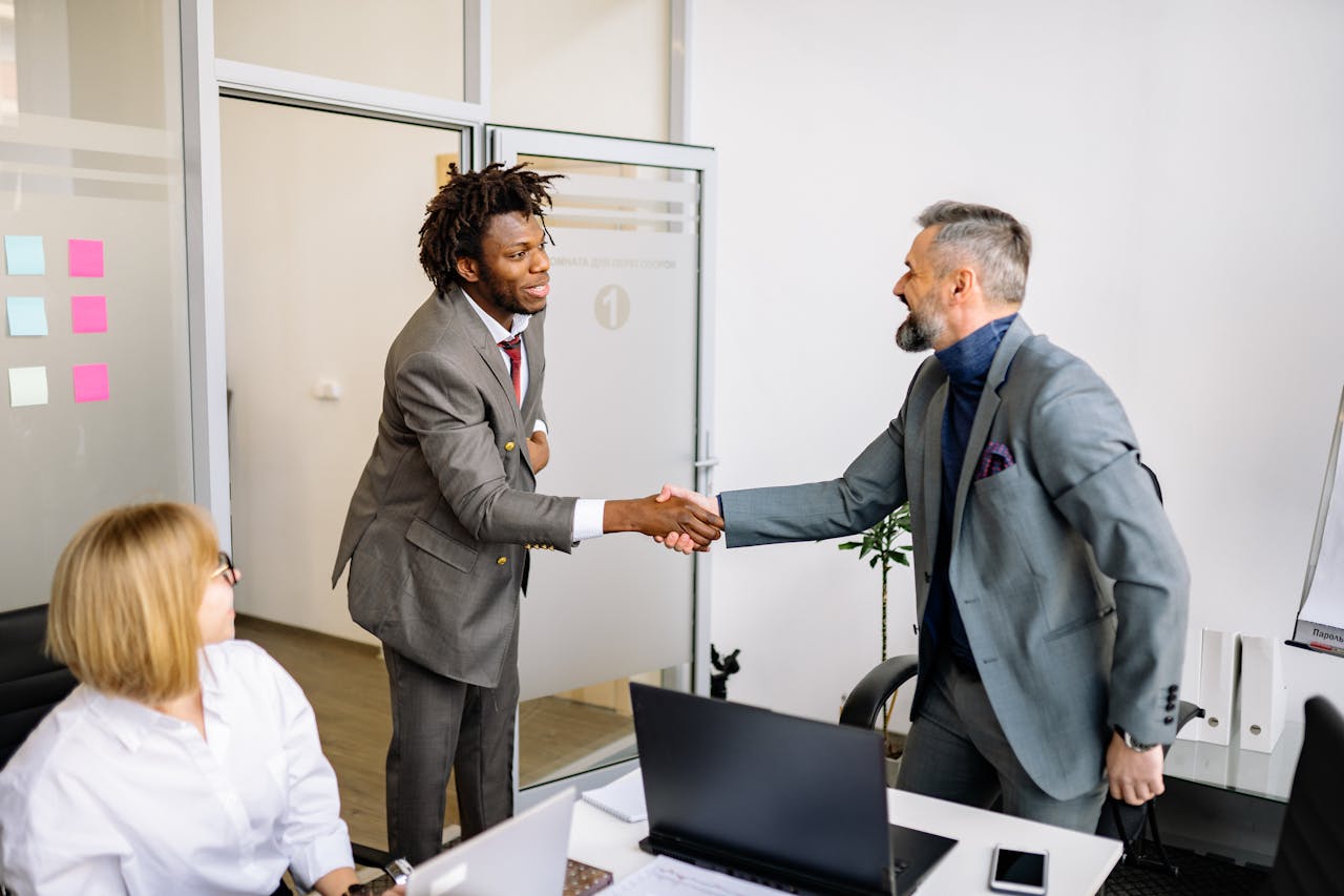 Two business professionals shaking hands in a modern office setting