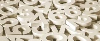 A scattered pile of large white 3D numbers overlapping one another.